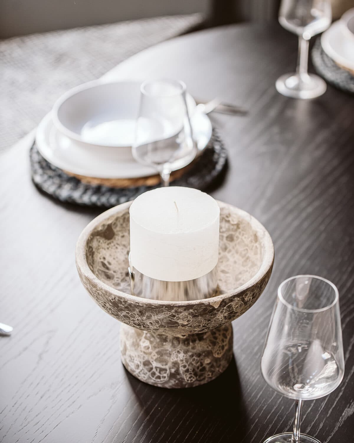 Dining table setting with stone candle holder and crystal glassware