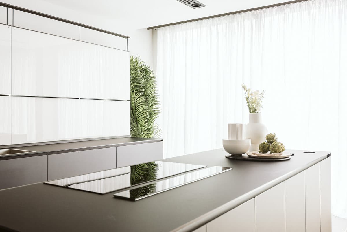 Contemporary London kitchen with dark stone island and sheer curtains